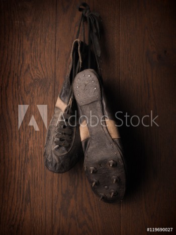 Picture of Old used sports shoes on a rustic wooden wall